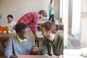 Creative business people working at laptop in office