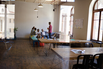 Creative business people working at tables in sunny office