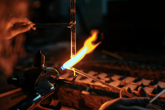 Close-up of two glass tubes being joined together with the torch flame of a glassblower