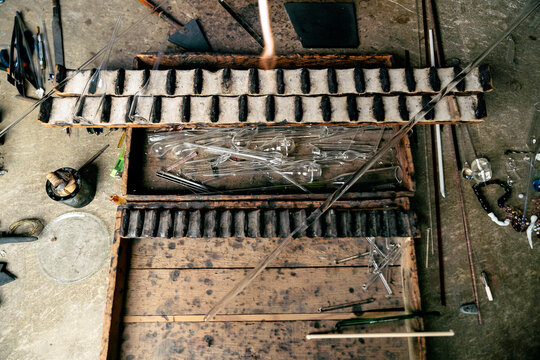 Top view of glassblower working table with different tools and glass tubes of various shapes