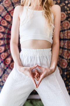 Young woman doing a vulva hand sign
