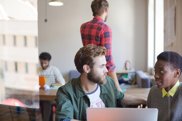 Creative business people working at laptop in office