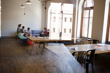Creative business people talking in circle in office