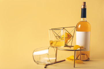 Glass and bottle of wine with decor on color background