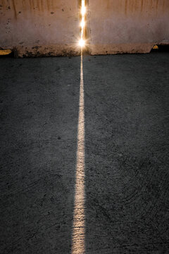 A fine line of sunlight on the concrete.