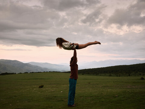 Acro yogic couple in field.