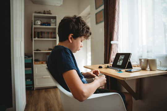 Young boy sitting at his desk in his room