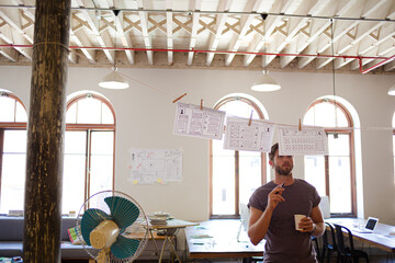 Fototapeta na wymiar Creative businessman brainstorming with hanging diagrams