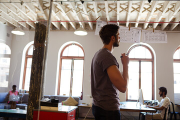 Creative businessman brainstorming with hanging diagrams