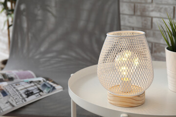 Stylish lamp on table in room