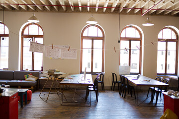 Laptops, digital tablet and paperwork on table in sunny office