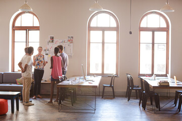 Creative business people talking in circle in office