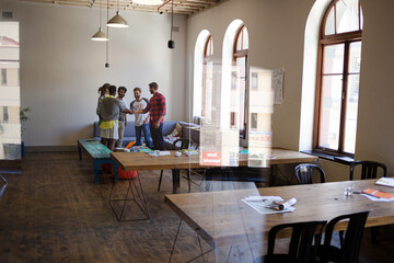 Casual business people joining hands in meeting in office