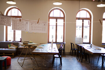 Laptops, digital tablet and paperwork on table in sunny office