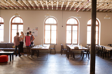 Creative business people talking in circle in office