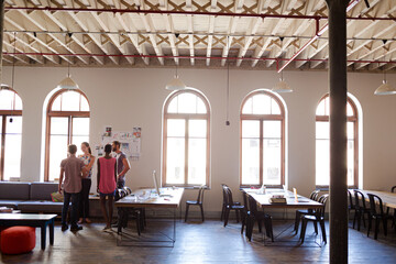 Creative business people talking in circle in office