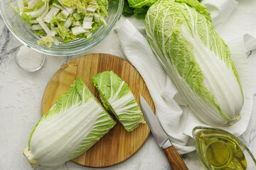 Board with fresh chinese cabbage on light background - obrazy, fototapety, plakaty