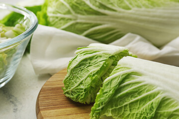 Board with fresh chinese cabbage on light background, closeup