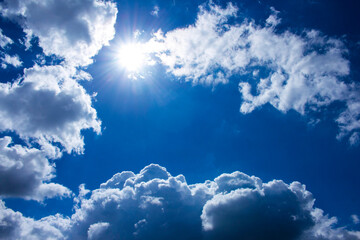 Bright blue sky with clouds and sun.