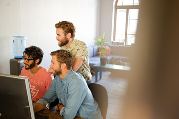 Obraz premium Focused casual businessmen working at computer in sunny office