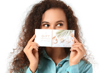 Young African-American woman with gift certificate for massage on white background