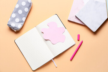 Blank notebook and stationery supplies on color background