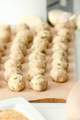 Board with uncooked cod cutlets on table, closeup