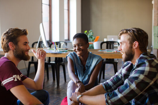 Casual business people meeting in circle in sunny office