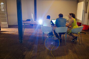 Lens flare over creative business people working in office
