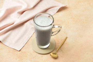 Glass cup of tasty Charcoal Latte on color background