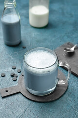 Glass cup of tasty Charcoal Latte on color background