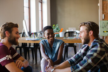 Casual business people meeting in circle in sunny office