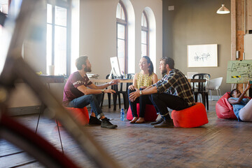 Creative business people working behind bicycle wheel in office