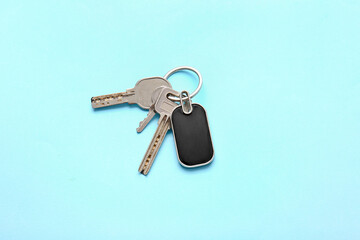 Keys with stylish keychain on color background
