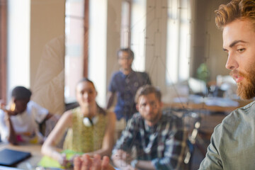 Casual businessman explaining diagram on glass in meeting