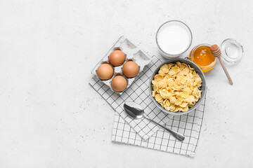 Ingredients for tasty breakfast with cornflakes on light background