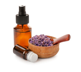 Bottles with essential oil and wooden bowl with lavender flowers on white background