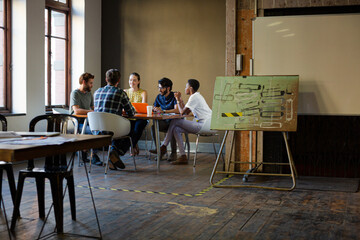 Creative business people working at tables in sunny office