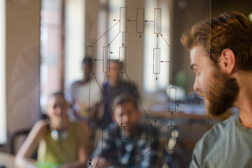 Casual businessman explaining diagram on glass in meeting