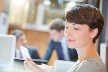 Businesswoman using cell phone in office