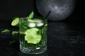 Glass of fresh mojito on dark background