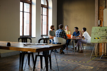 Creative business people working at tables in sunny office