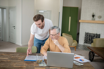 Two men working together on a project and looking interested
