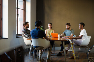 Casual business people meeting in circle in sunny office