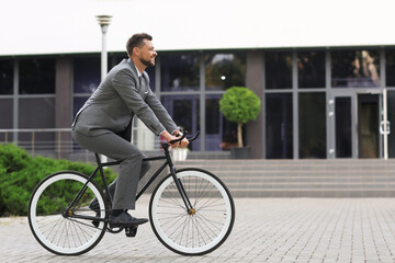 Businessman going to work by bicycle on city street
