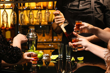 Women with shots of tasty tequila in bar