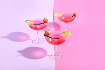 Glasses of tasty cosmopolitan cocktail on color background