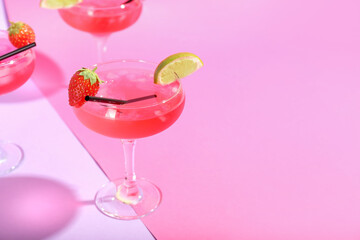 Glasses of tasty cosmopolitan cocktail on color background