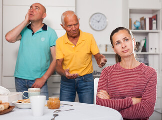 Elderly father together with his adult son scold the daughter-in-law at home. High quality photo