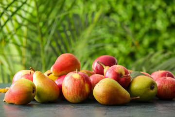Ripe pears and apples on table outdoors